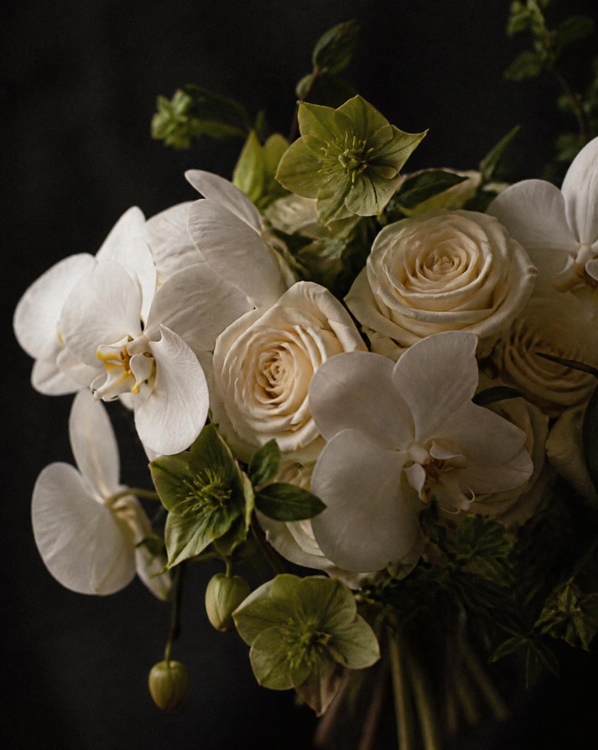 A close study of white orchids, cream roses and green hellebore