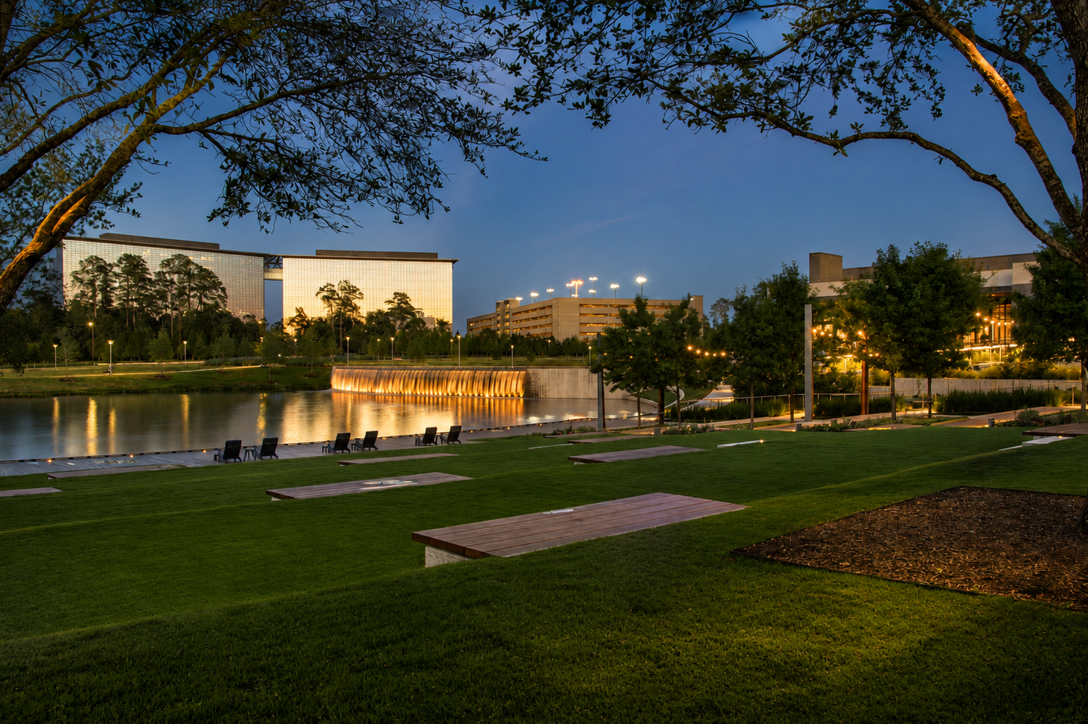 The CityPlace lawn, lake and illuminated water wall beside the hotel at twilight